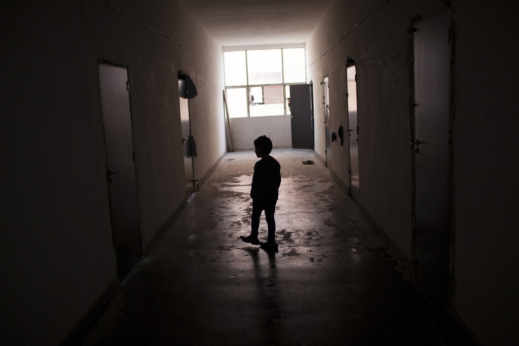 A Syrian boy walks along a corridor inside a refugee camp in Harmanli, 280 km (173 miles) east of Sofia, December 9, 2013. According to UNHCR, Bulgaria is currently hosting some 8,800 asylum seekers and refugees, around two-thirds of them being Syrians. Bulgaria, the European Union's poorest country, on average receives only around 1,000 asylum seekers and refugees a year. REUTERS/Pierre Marsaut (BULGARIA - Tags: SOCIETY IMMIGRATION POLITICS) - RTX16B1R