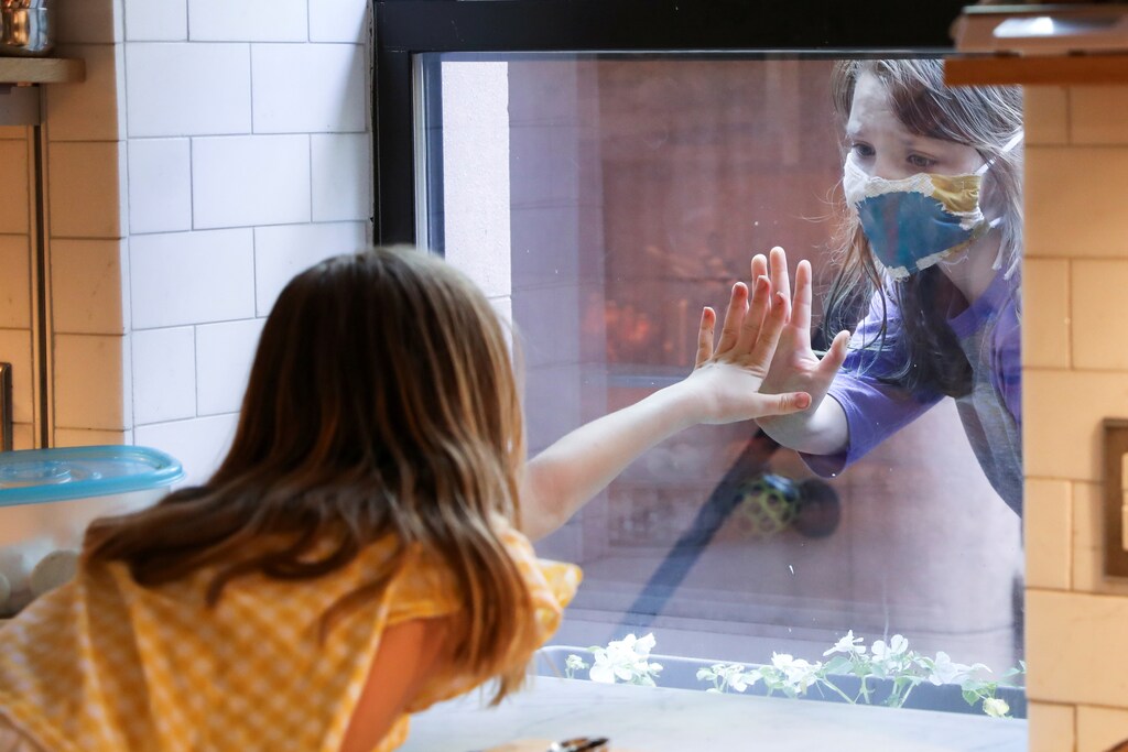 Lydia Hassebroek says hi to her friend Rose through her kitchen window during the outbreak of the coronavirus disease (COVID-19) in Brooklyn, New York, U.S., May 17, 2020. REUTERS/Caitlin Ochs TPX IMAGES OF THE DAY - RC2PQG9LYHUB