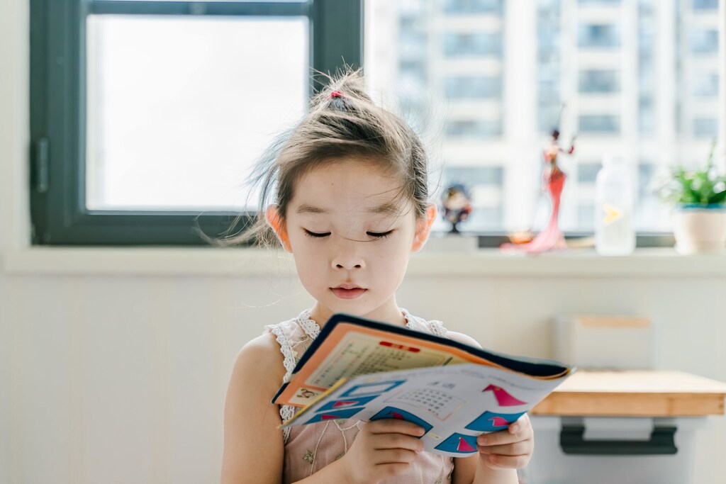 A girl reads a school book at home