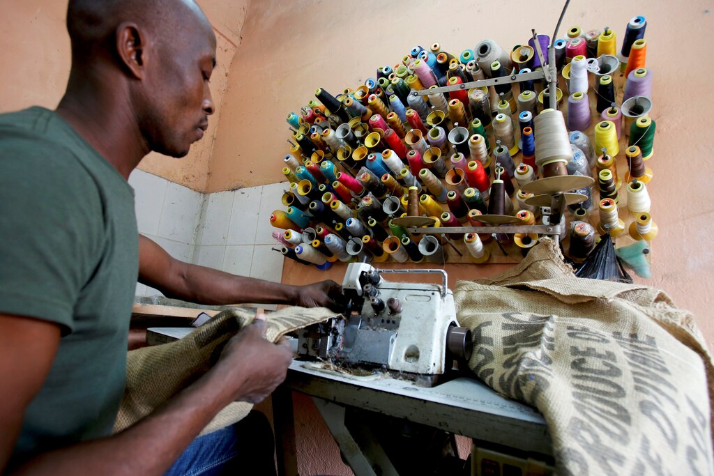A man works on a sewing machine inside the workshop of Ivory coast fashion designer Liliane Estievenart, 45, in Abidjan, Ivory Coast July 22, 2017. Picture taken July 22, 2017. REUTERS/Thierry Gouegnon - RC151B9D8610