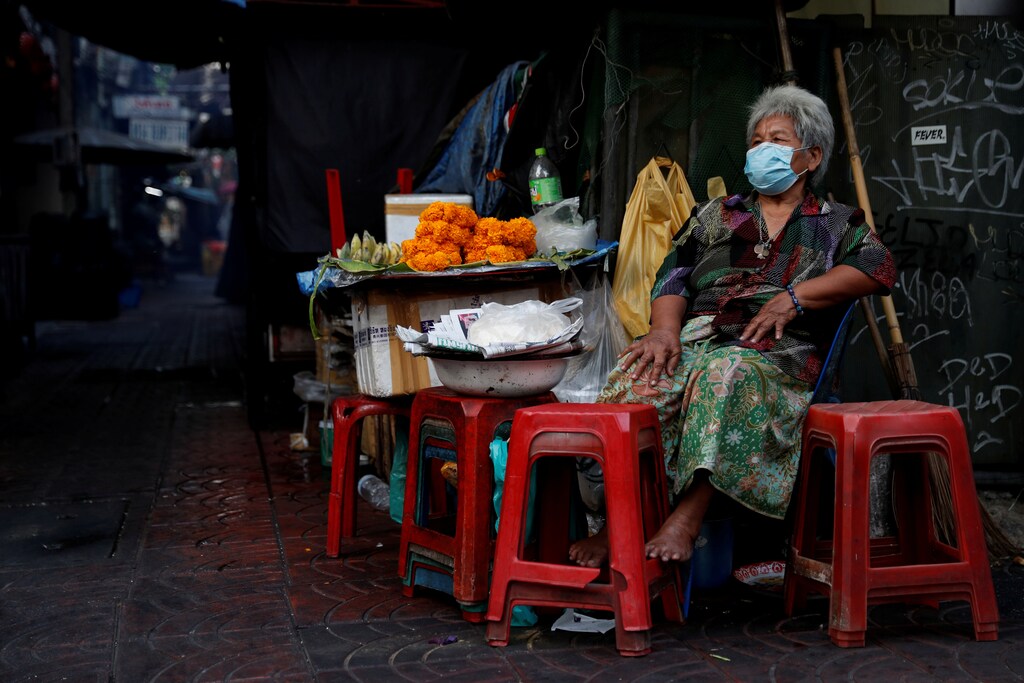 A woman wearing a protective face mask waits for customers, as the spread of the coronavirus disease (COVID-19) continues, in Chinatown, Bangkok, Thailand March 30, 2020. REUTERS/Jorge Silva - RC2BUF9LEK6F