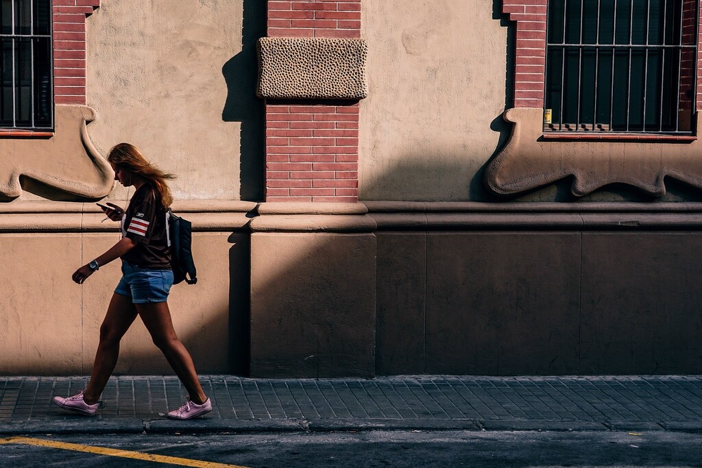 Women walking while looking at phone