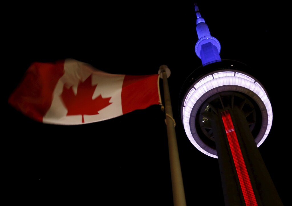 The landmark CN Tower is lit blue, white and red in the colors of the French flag following Paris attacks, in Toronto November 13, 2015. Canadian Prime Minister Justin Trudeau said on Friday it was too soon to say whether the deadly attacks in Paris would prompt him to reconsider his pledge to withdraw Canada from airstrikes against Islamic State militants in the Middle East.
