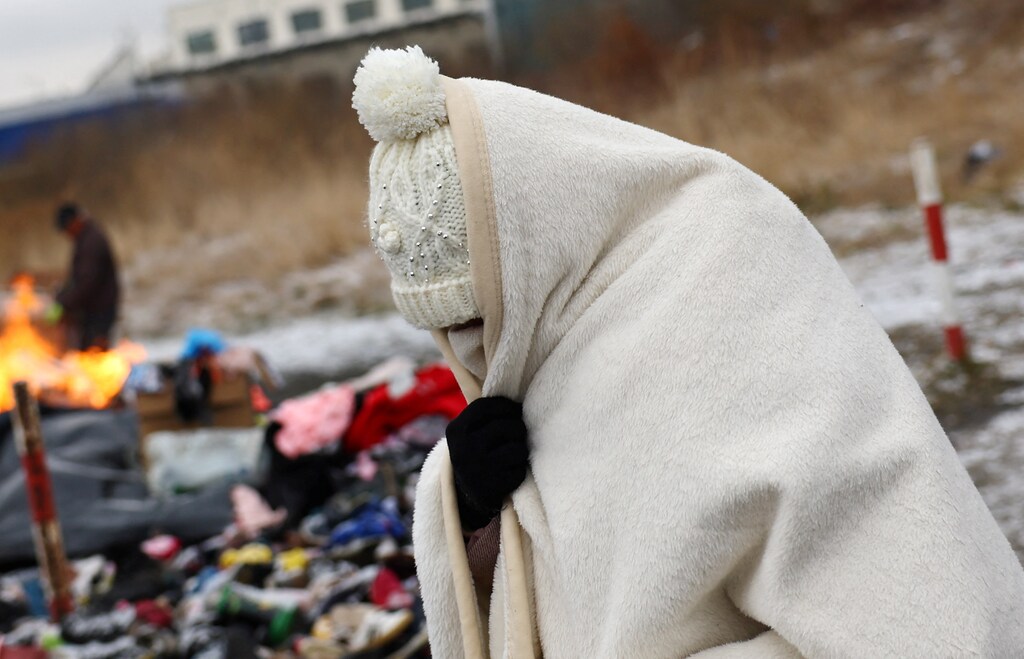 A woman tries to stay warm after fleeing Ukraine following the Russian invasion, at the border checkpoint in Medyka, Poland, February 28, 2022. REUTERS/Kai Pfaffenbach