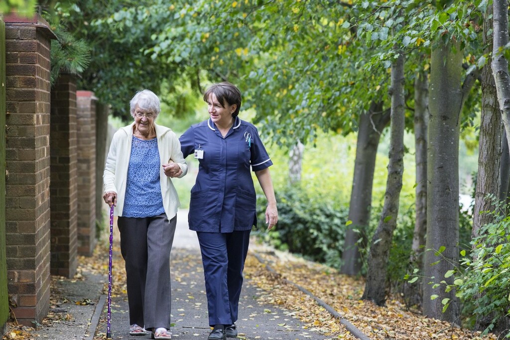 image of a care worker walking with an elderly lady