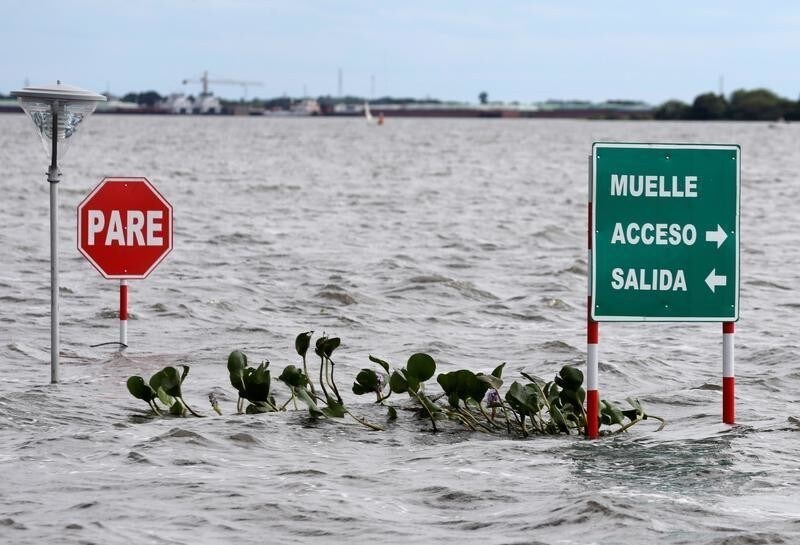 Street signs are seen in a flooded street after heavy rains caused Paraguay River to overflow, in a neighbourhood on the outskirts of Asuncion, Paraguay May 26, 2019. Picture taken May 26, 2019. The signs read: "Stop" and "Muelle, access, exit". REUTERS/Jorge Adorno - RC1A8AF00530