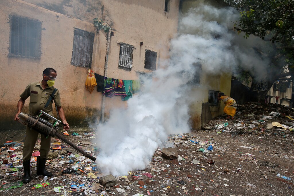 A municipal worker fumigates a slum area to prevent the spread of dengue fever and other mosquito-borne diseases in Mumbai, India, July 19, 2017. REUTERS/Shailesh Andrade TPX IMAGES OF THE DAY - RC14EF8C63C0