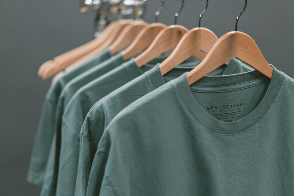 Green T-shirts on hangers.