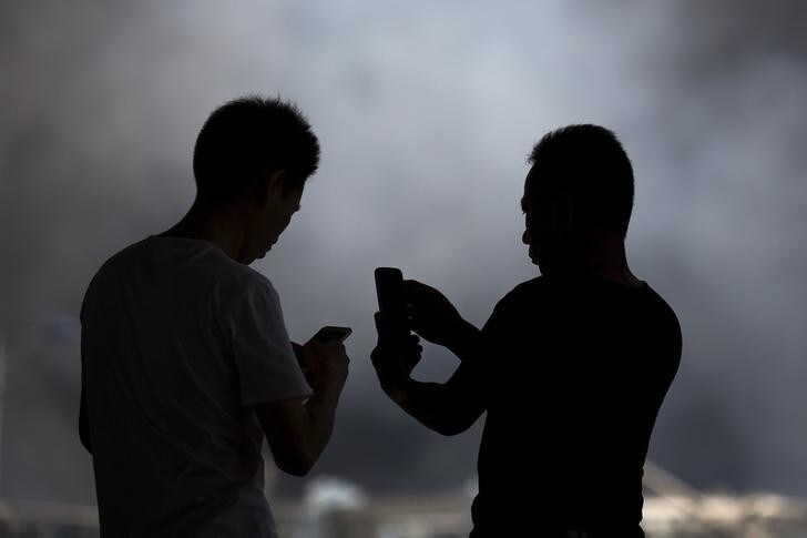 People take pictures at the explosion site in Binhai new district in Tianjin, China August 13, 2015. Two huge explosions tore through an industrial area where toxic chemicals and gas were stored in the northeast Chinese port city of Tianjin, killing at least 44 people, including at least a dozen fire fighters, officials and state media said on Thursday. REUTERS/Damir Sagolj