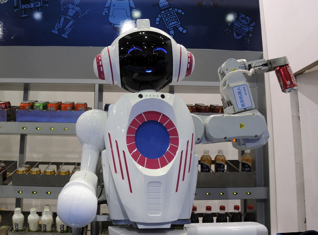 A sales assistant robot picks up a can of Coca Cola during a demonstration at the World Robot Conference in Beijing, China, November 24, 2015. The conference, which kicked off in Beijing on Monday, is a three-day event including a forum, an exhibition and a robot contest for youth, Xinhua News Agency reported. Picture taken November 24, 2015. REUTERS/Stringer CHINA OUT. NO COMMERCIAL OR EDITORIAL SALES IN CHINA - RTX1VPX3