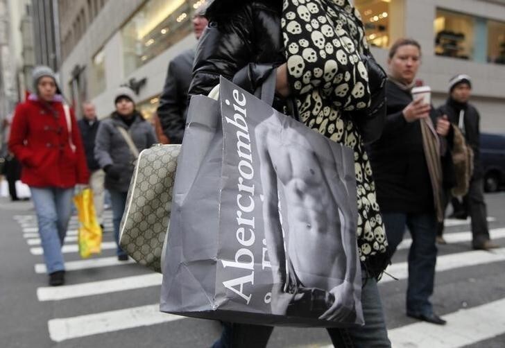 Shoppers carry bags as they walk down Fifth Avenue in New York, December 6, 2008. U.S. consumers struggling with recession were willing to shop more for clothes in November because of extreme discounting and colder weather after months of avoiding apparel purchases. Shares of Abercrombie & Fitch rose as high as 13 percent even though a 28 percent drop in November same-store sales was below Wall Street estimates. REUTERS/Chip East (UNITED STATES)