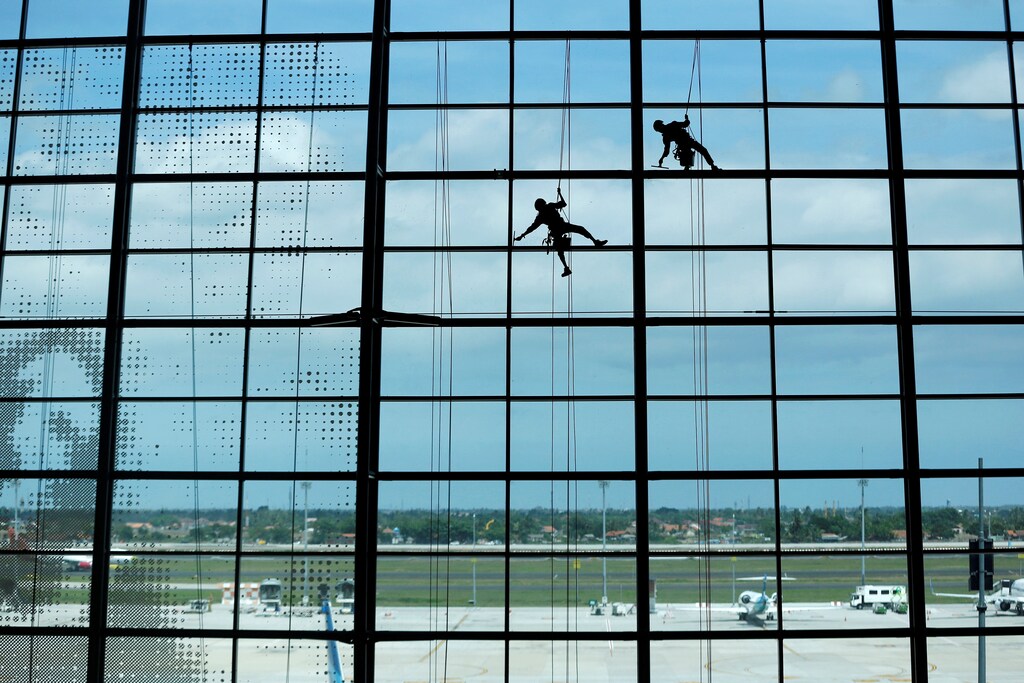 Workers clean a glass window at Terminal 3 Ultimate of Soekarno-Hatta International Airport near Jakarta, Indonesia, December 29, 2018. REUTERS/Willy Kurniawan TPX IMAGES OF THE DAY - RC1EED3FA780