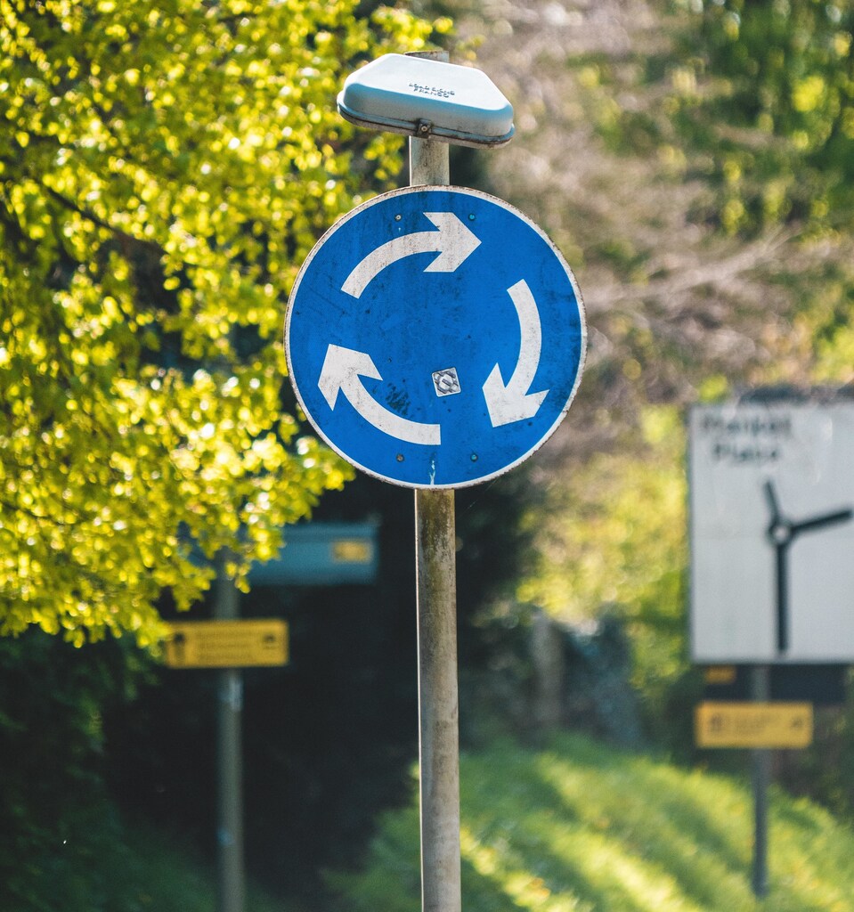 This image shows a circular roundabout sign, illustrating how a circular economy can aid decarbonization