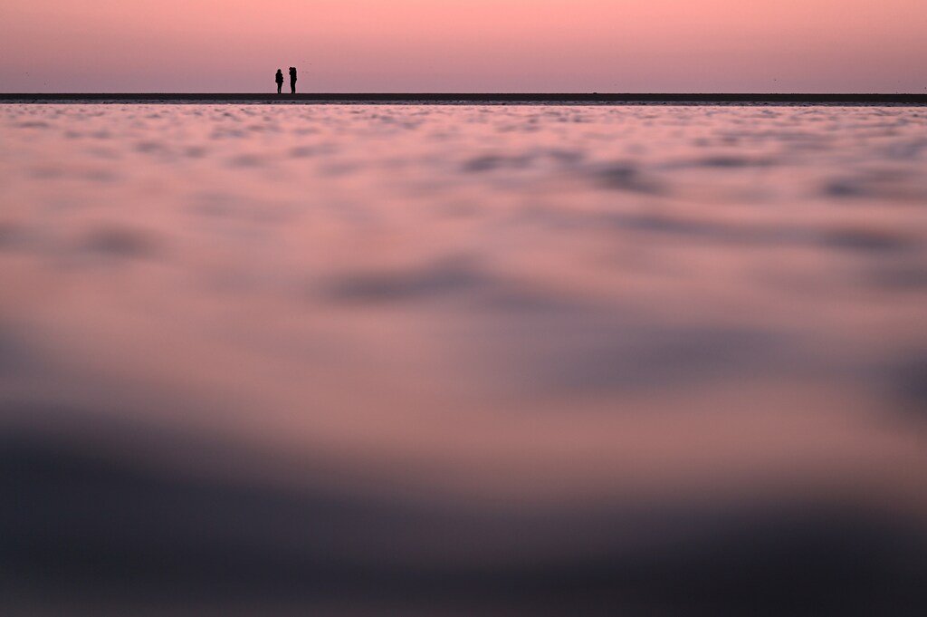 People walk along Sandymount strand at sunset, amid the spread of coronavirus disease (COVID-19), in Dublin, Ireland, March 21, 2021. REUTERS/Clodagh Kilcoyne TPX IMAGES OF THE DAY - RC2WFM9SAOZF