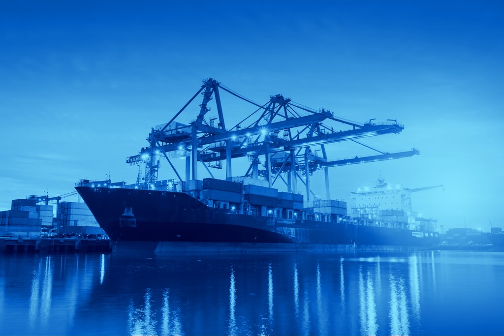 Containers loading with crane or trade Port at sunrise: Capital flows are evolving toward a new economic world order.