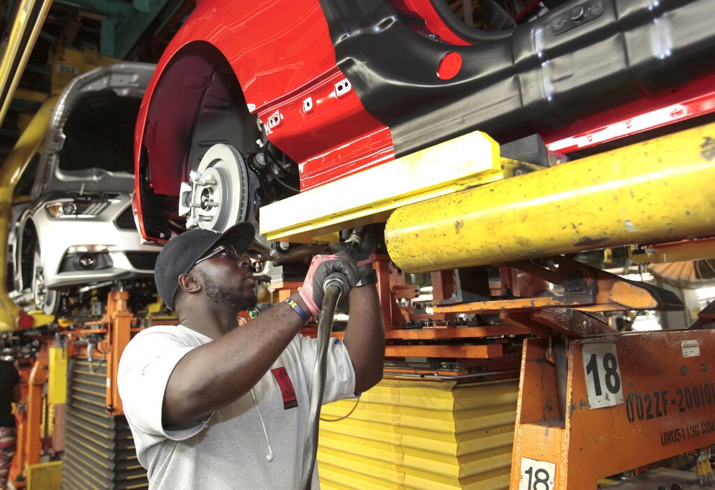 An assembly worker works on 2015 Ford Mustang vehicles on the production line at the Ford Motor Flat Rock Assembly Plant in Flat Rock, Michigan, August 20, 2015.