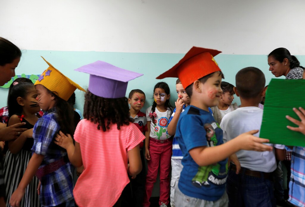 Students wearing handmade graduation hats take part in an activity for the end of the school year at the Padre Jose Maria Velaz school in Caracas, Venezuela July 12, 2016.