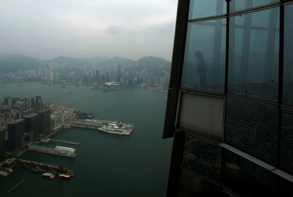 A worker at "sky100", the 100th floor of the International Commerce Centre (ICC), looks at Hong Kong's Victoria Harbour March 23, 2011. REUTERS/Bobby Yip/File Photo GLOBAL BUSINESS WEEK AHEAD PACKAGE - SEARCH BUSINESS WEEK AHEAD SEPTEMBER 26 FOR ALL IMAGES - RTSPE86