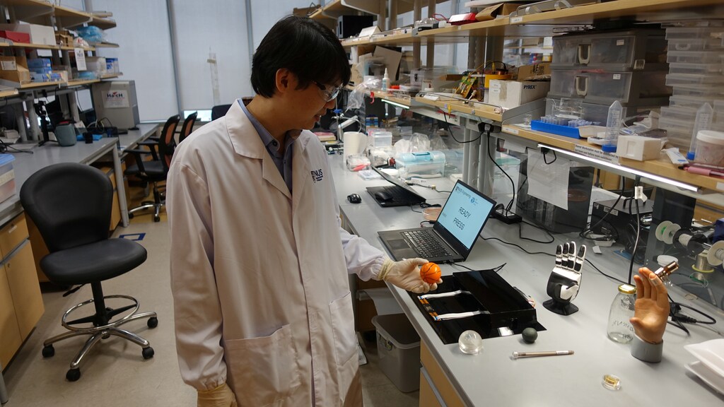 Dr. Benjamin Tee, Assistant Professor of Materials Science and Engineering at the National University of Singapore (NUS), prepares to demonstrate how his device can detect the texture of a soft stress ball at a lab in NUS, Singapore July 27, 2020. Picture taken July 27, 2020. REUTERS/Joseph Campbell - RC296I9WW327