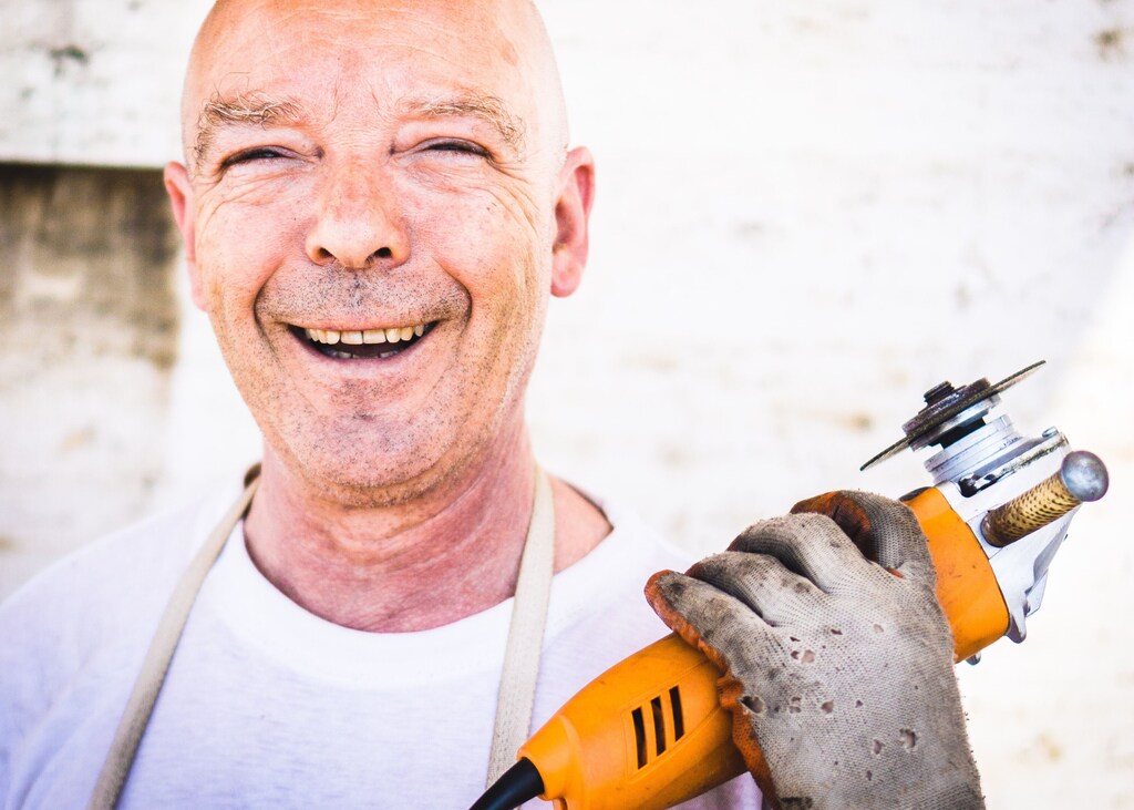 An older worker holding a tool, illustrating the longevity economy