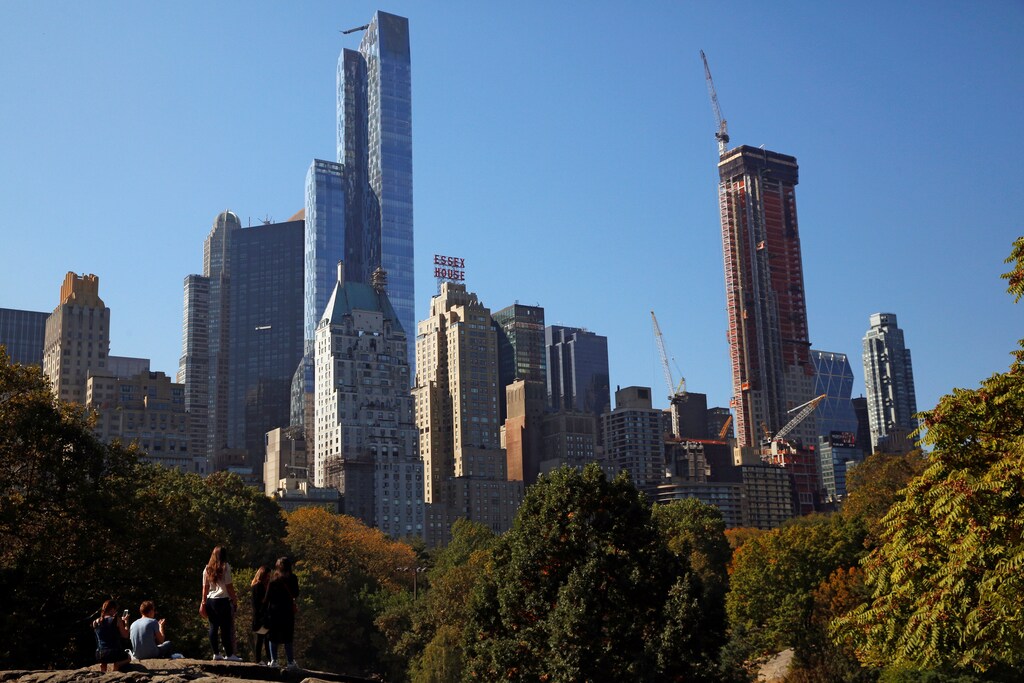 People enjoy the warm weather in Central Park as they look at midtown Manhattan in New York City, U.S., October 18, 2016. REUTERS/Brendan McDermid - RTX2PDM5