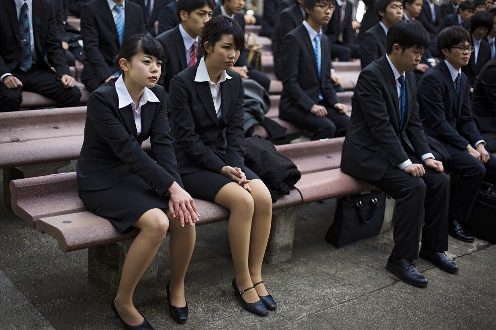 Japanese college graduates listen to speeches during a job-hunting rally at an outdoor theatre in Tokyo February 20, 2015. Some 1500 graduates from Japanese vocational schools attended a pep rally designed to boost their morale as they break into the job market this year. REUTERS/Thomas Peter (JAPAN - Tags: SOCIETY BUSINESS EMPLOYMENT EDUCATION) - RTR4QCSW