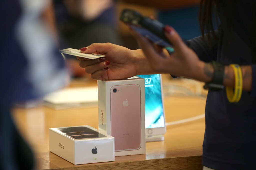 A customer buys the new iPhone 7 smartphone inside an Apple Inc. store in Los Angeles, California, U.S., September 16, 2016. REUTERS/Lucy Nicholson - RTSO2V4