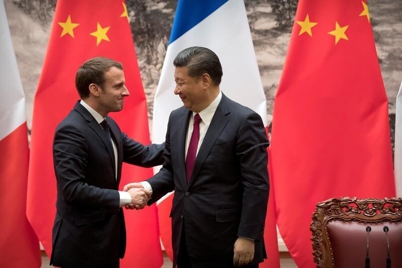 French President Emmanuel Macron, left, and Chinese President Xi Jinping shake hands after a joint press briefing at the Great Hall of the People in Beijing, China January 9, 2018. REUTERS/Mark Schiefelbei/Pool - RC1CF5C95F50