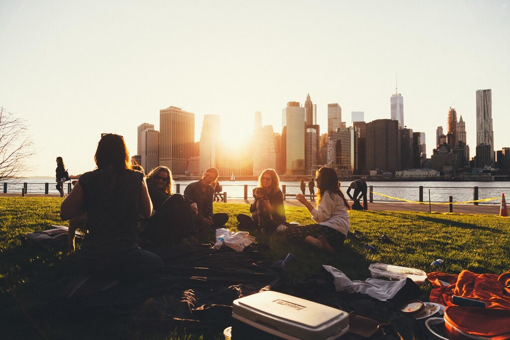 Friends sit in a park as friendships can help alleviate inequality.
