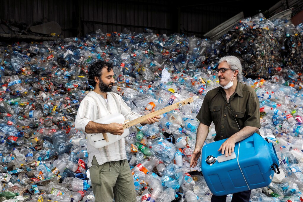 Musicians Roni Aran and Herman Artuc, members of the ethnic instrumental music band of Fungistanbul, perform with instruments made by materials collected from landfills, at a recycling depot in Istanbul, Turkey June 17, 2021. Picture taken June 17, 2021. REUTERS/Umit Bektas - RC2B2O9E3TKU