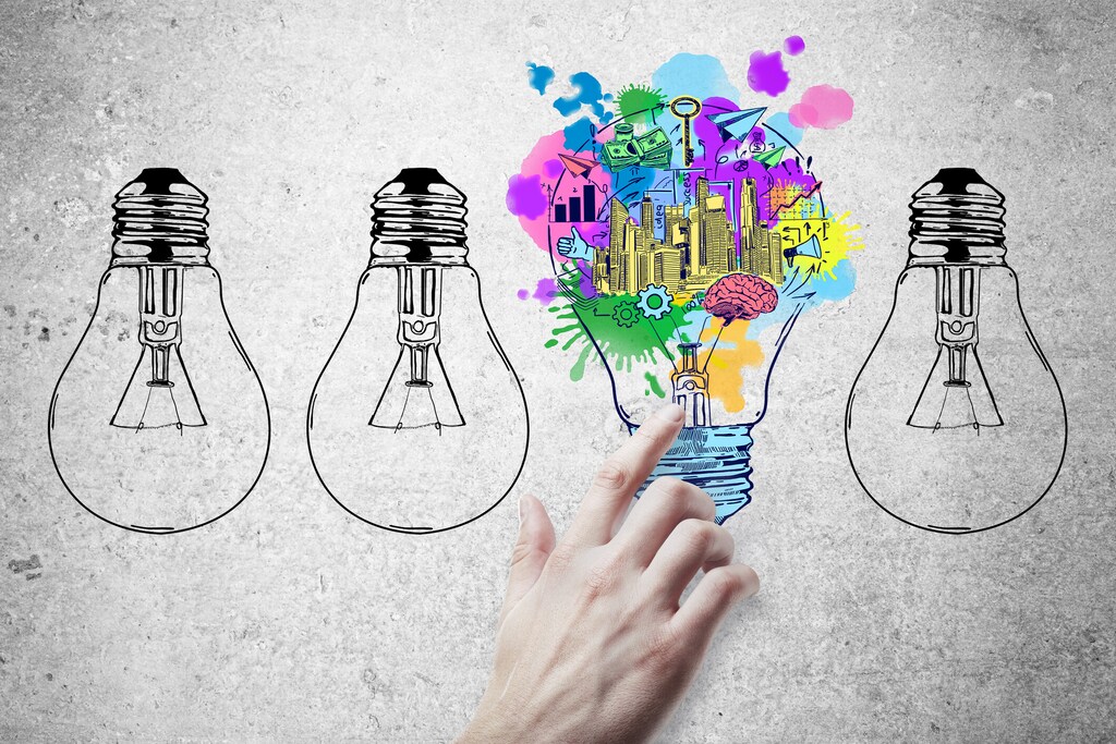 Hand pointing at abstract drawn lamps and business sketch on concrete background. Idea concept; circular economy; start-ups