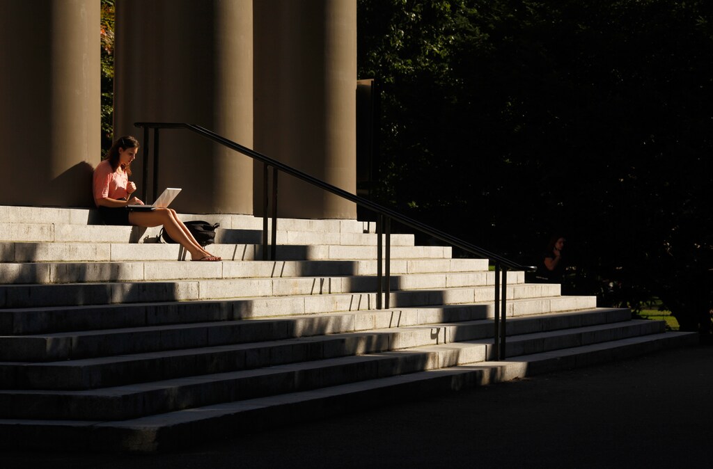 A student uses her laptop computer on the steps to Memorial Church at Harvard University in Cambridge, Massachusetts September 21, 2009. REUTERS/Brian Snyder (UNITED STATES) - RTR285P2