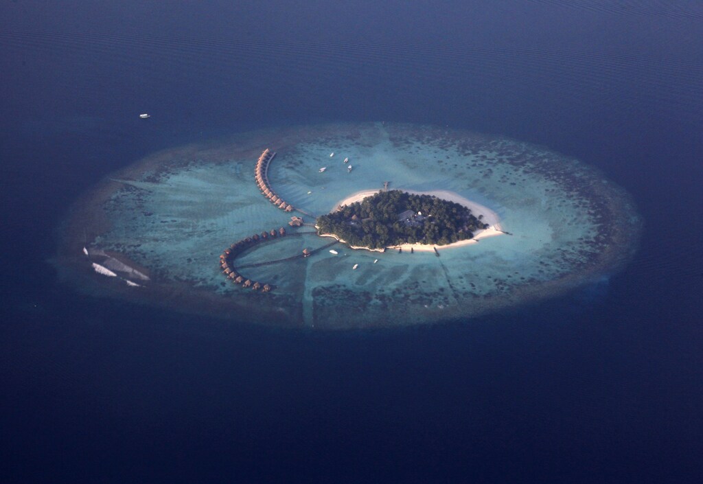 An areal view shows a resort island in the Maldives December 14, 2009. Maldives has a population of some 400,000 islanders, whose livelihood from fishing and tourism is being hit by climate change. Maldives President Mohamed Nasheed said in November that 2 degrees Celsius warming would risk swamping the sand-rimmed coral atolls and islets, dotted with palm trees and mangrove clumps, that form his small country.