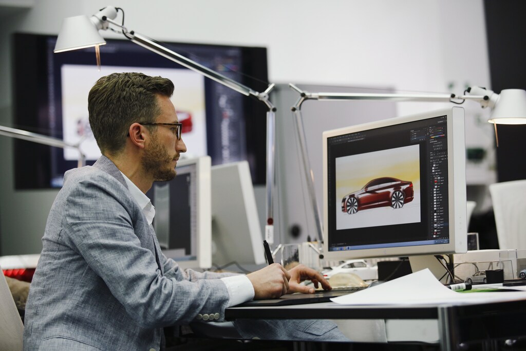 A man works in a showcase design studio at the fringes of a launch ceremony presenting the new Volkswagen Passat at the Volkswagen Design Center in Potsdam July 3, 2014. Volkswagen is steering the Passat upscale, aiming to lift its No.2 selling model clear of a struggling market for mid-priced cars without alienating its core family customers. At about 26,000 euros ($35,500), it will be priced only slightly above the current version, a company source said, but come in below BMW's 3-Series at 29,350 euros and the Mercedes-Benz C-Class at 33,558 euros.