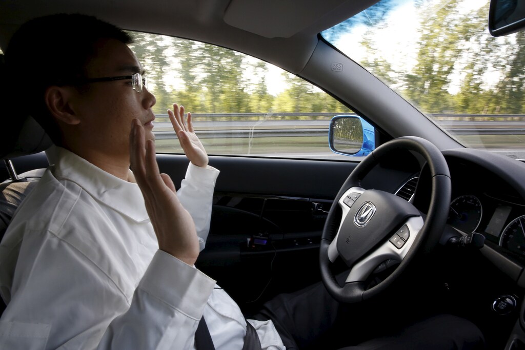 Li Zengwen, a development engineer at Changan Automobile, lifts his hands off the steering wheel as the car is on self-driving mode during a test drive on a highway in Beijing, China, April 16, 2016. REUTERS/Kim Kyung-Hoon - RTX2BA9H