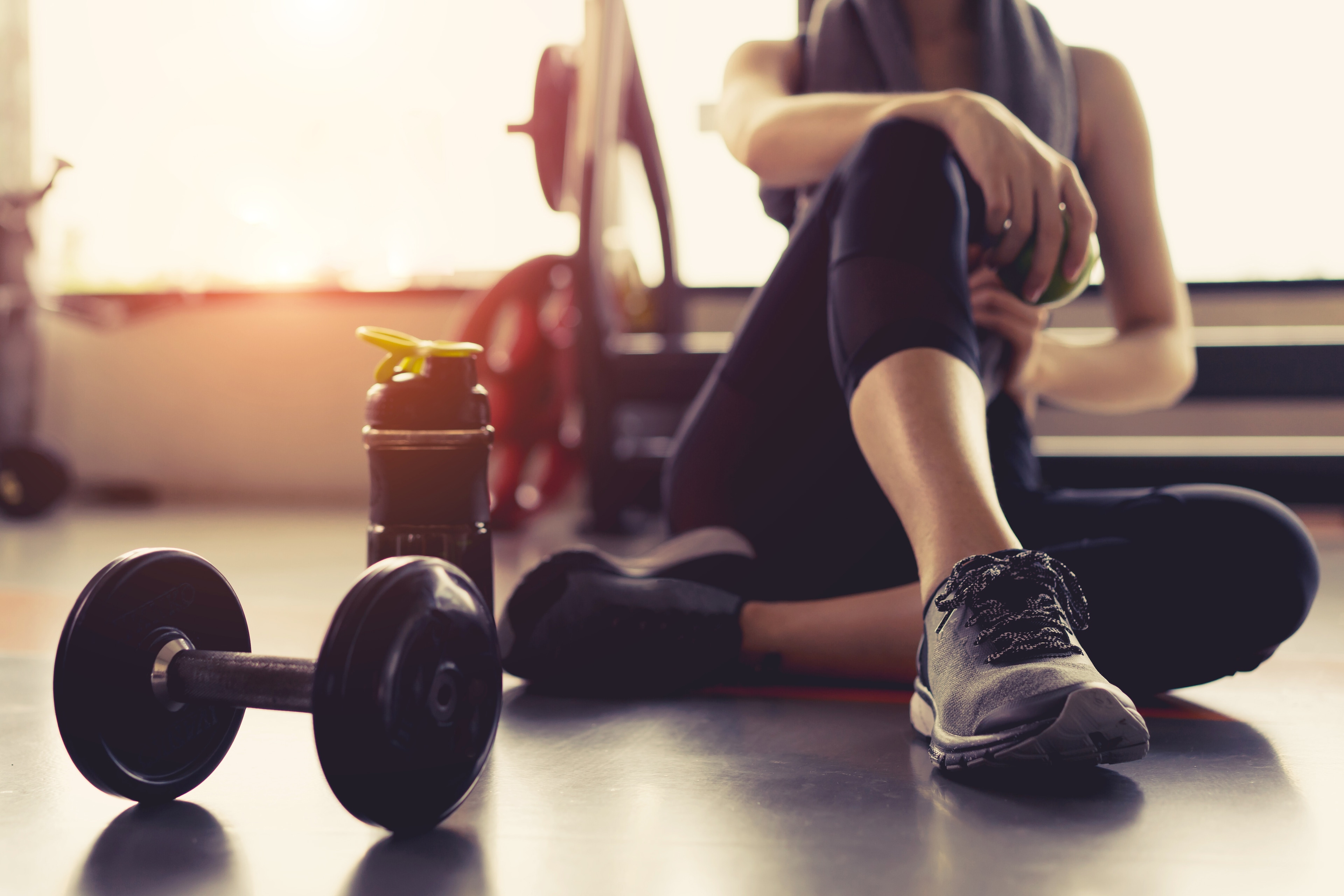 Woman rests after a workout in the gym. By encouraging movement and exercise, employers around the world have a unique opportunity to help build a physically and mentally healthy workforce.