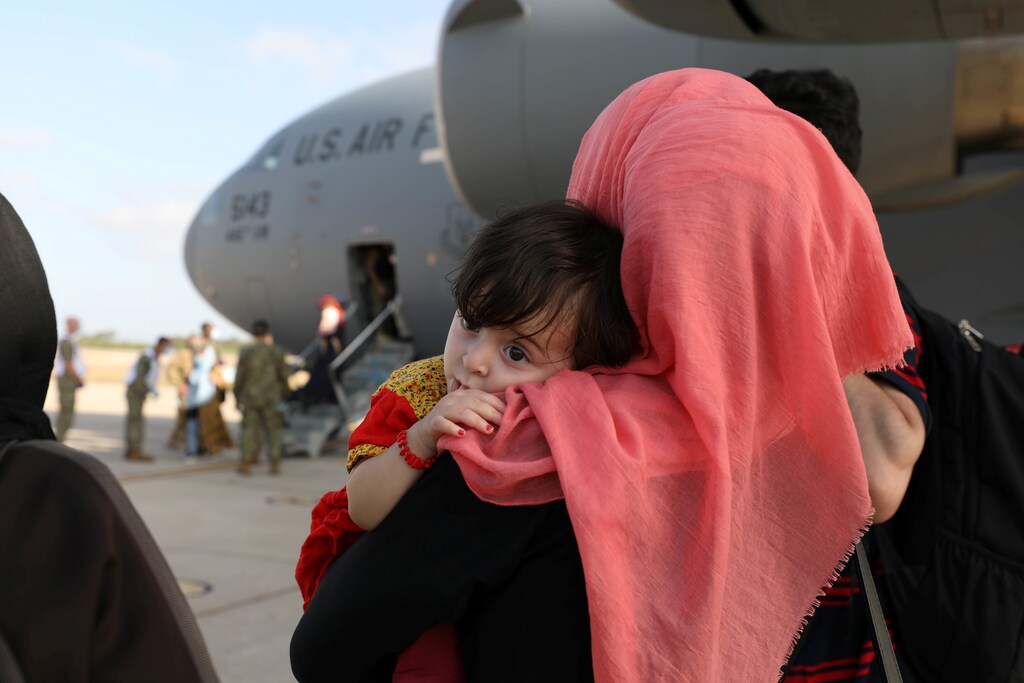 Part of group of 450 Afghan citizens who have been evacuated from Kabul watch as other compatriots leave a U.S. Air Force C-17 Globemaster III transport plane after arriving from Kuwait, at Naval Station (NAVSTA) Rota Air Base in Rota, southern Spain, August 27, 2021. Picture taken August 27, 2021.