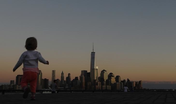 A girl plays in front of the skyline of New York's Lower Manhattan and One World Trade Center in a park along the Hudson River in Hoboken, New Jersey, September 5, 2013. New York will mark the 12th anniversary of the 9/11 attack on the World Trade center next week. REUTERS/Gary Hershorn (UNITED STATES - Tags: CITYSCAPE ANNIVERSARY)