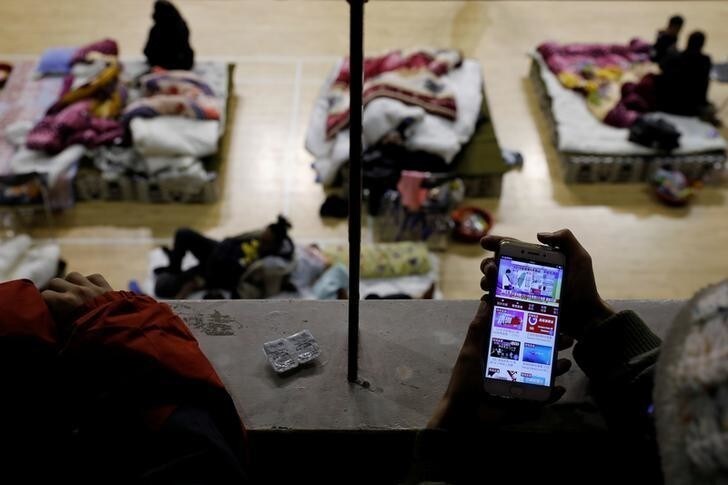 A resident watches news about the earthquake as she takes shelter at a local stadium in Hualien, Taiwan February 7, 2018. Picture taken February 7, 2018. REUTERS/Tyrone Siu