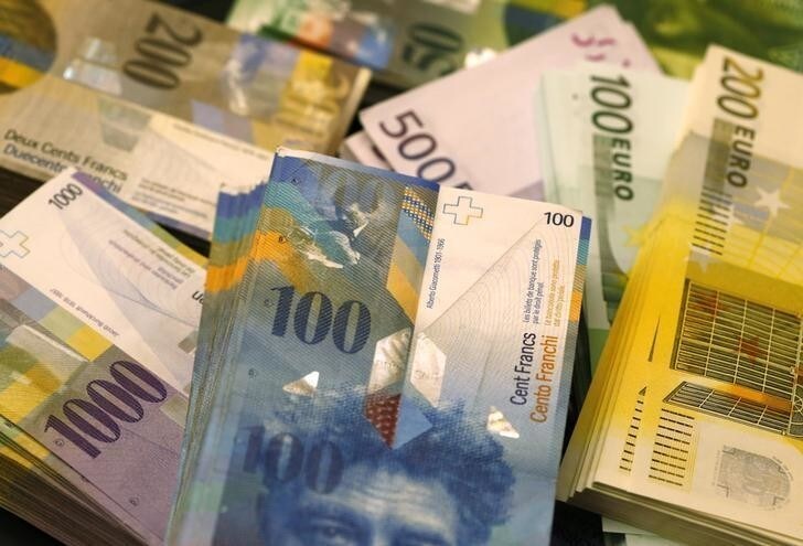 Swiss Franc and Euro banknotes of several values lie on a table in a Swiss bank in Bern November 25, 2014. The "Save our Swiss gold" proposal, spearheaded by the right-wing Swiss People's Party (SVP), aims to ban the central bank from offloading its reserves and oblige it to hold at least 20 percent of its assets in gold. The referendum is scheduled for November 30. The SVP argues it would secure a stable Swiss franc. Picture taken November 25, 2014. REUTERS/Ruben Sprich (SWITZERLAND - Tags: POLITICS BUSINESS)