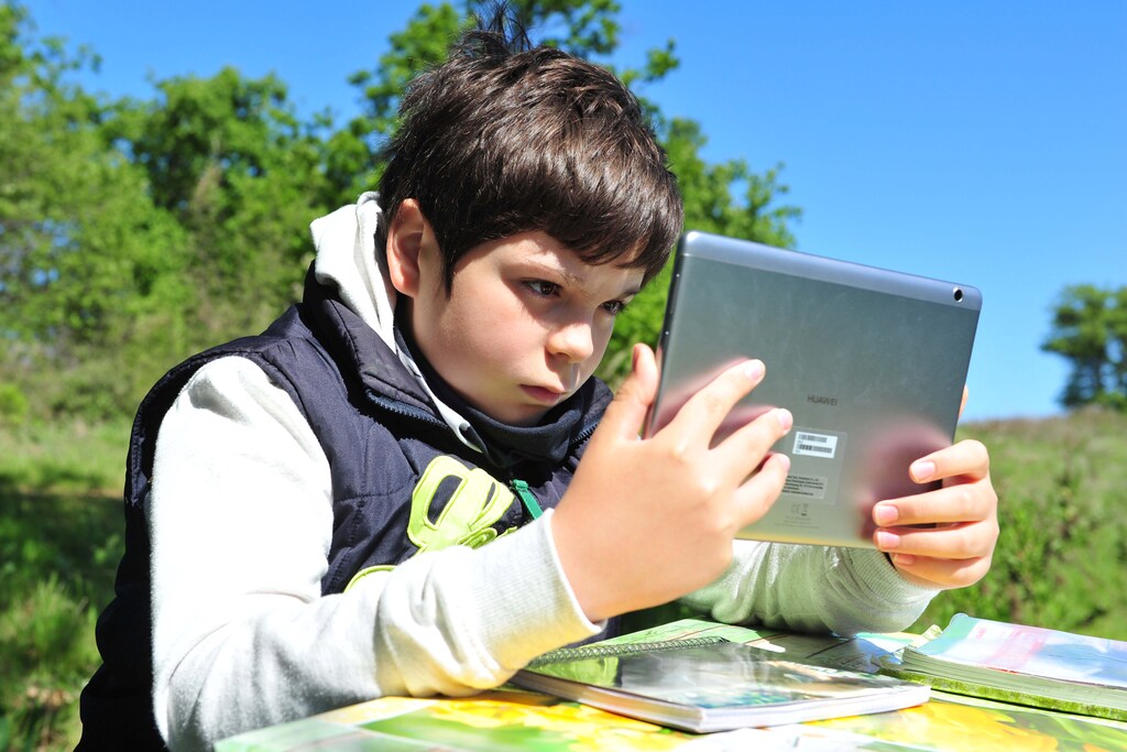 Giulio Giovannini, 12, with a tablet, a small camping table and a chair, studies on the top of a hill where he is able to access the Internet so he can participate in online lessons while schools remain closed due to the spread of the disease from coronavirus (COVID-19), in Scansano, Italy, April 15, 2020. REUTERS/Jennifer Lorenzini - RC205G91UR4B