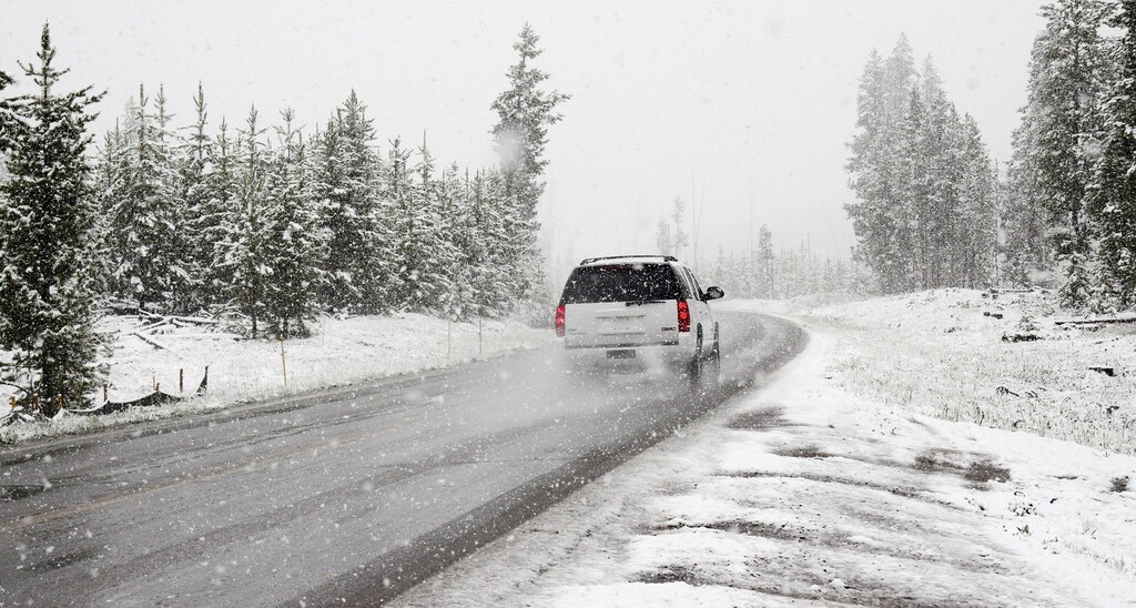 Image of car travelling on a road in the snow