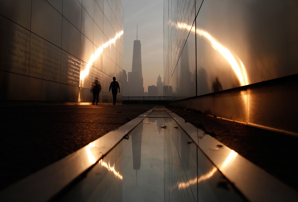A man walks through the 9/11 Empty Sky memorial at sunrise across from New York's Lower Manhattan and One World Trade Center in Liberty State Park in Jersey City, New Jersey, September 11, 2013