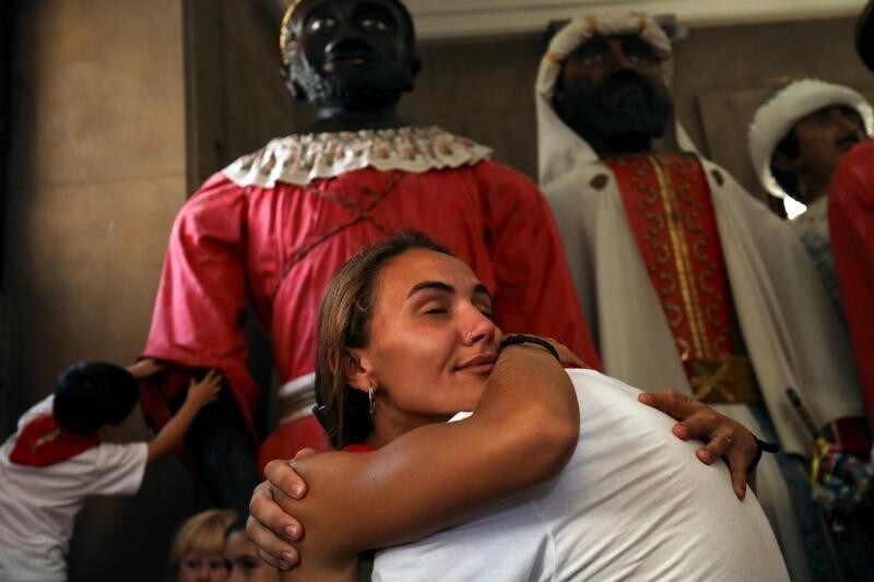 Members of the "Comparsa de gigantes y cabezudos" (Parade of the giants and the big heads) get emotional after a farewell ceremony on the last day of San Fermin festival's "Comparsa de gigantes y cabezudos" in Pamplona, northern Spain, July 14, 2018.