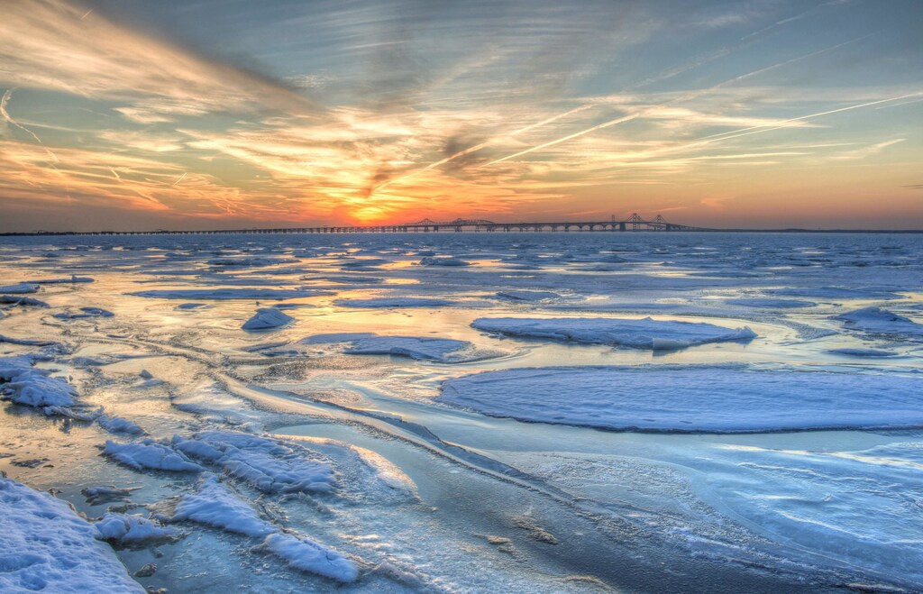 A snow-covered field during sunset