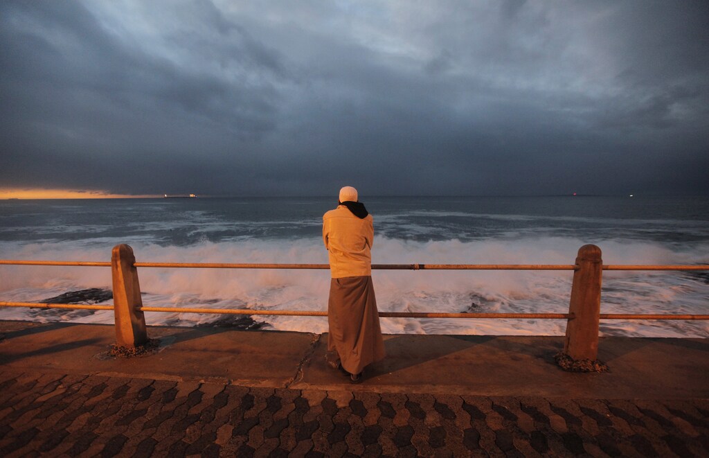 A Cape Town Muslim awaits the sighting of the crescent moon marking Eid al-Fitr, the end of Ramadan, the holiest month in the Islamic calendar, along the city's Sea Point beachfront, September 9, 2010. REUTERS/Mike Hutchings (SOUTH AFRICA - Tags: RELIGION SOCIETY) - GM1E69A0FEG01