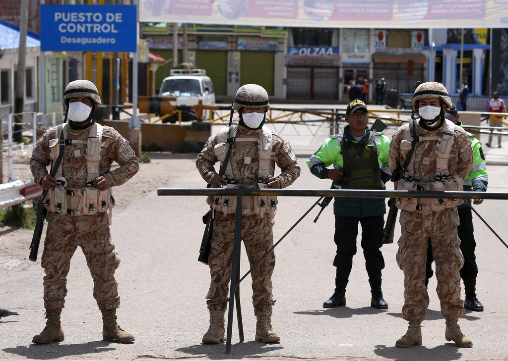 Peruvian soldiers stand at the border between Peru and Bolivia after Peru's government's announcement of the border closure in a bid to slow the spread of the new coronavirus (COVID-19), in Desaguadero, Bolivia, March 17, 2020. REUTERS/David Mercado - RC2YLF9WLQ29