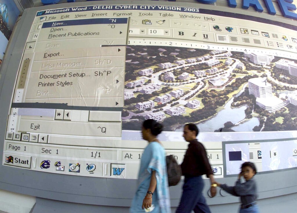 Visitors pass a billboard showing a large computer screen at a stall during a fortnight-long international trade fair in New Delhi November 16. Authorities in the Indian capital are hoping to make Delhi a "cyber city" by 2003. ??» - RTXJBJB