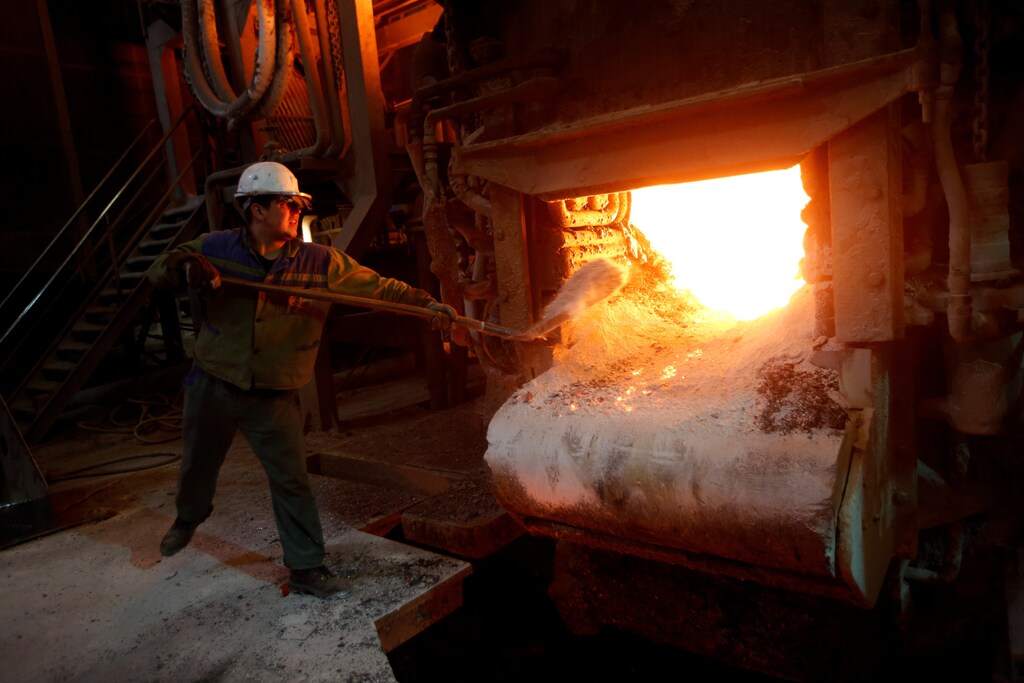 A worker throws quartz sand in an electric arc furnace in a steel factory of Store Steel in Store, Slovenia November 17, 2016.