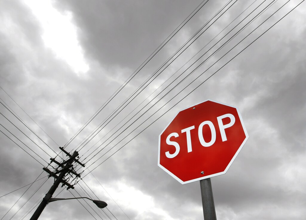 A street sign stands below electricity power lines in suburban Sydney December 15, 2008. Australia on Monday committed to start the most sweeping carbon trade scheme outside Europe in mid-2010, as planned, despite business calls for a delay due to the global financial crisis. REUTERS/Tim Wimborne (AUSTRALIA) - GM1E4CF0R6K01